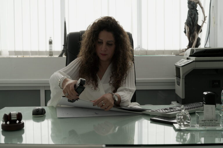 עורכת הדין פרי מהדקת את הדפים